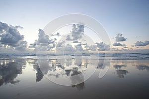 Wonderful landscape, ocean at dawn. Reflection of clouds in incoming wave. Beautiful clouds, early in morning, before sunrise.