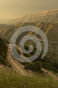 Wonderful panorama with mountain landscape - majestic folded green ridges with country road in thunderstorm weather on sunset.