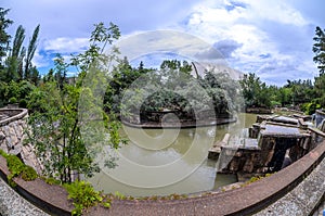 A wonderful picturesque park. Lots of vegetation and a lake with ducks. Fountain, firs, arborvitae, wild grapes.