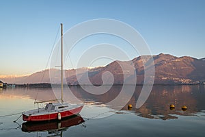 Wonderful red boat on stunning mountain Iseo lake