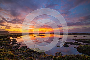 Wonderful seascape. Beach at sunset during low tide. Sunset golden hour. Sunlight refletion in water. Colorful sky with clouds. photo