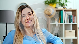 Wonderful smiling girl with a lovely look and natural make up looking at camera at cozy room. Close-up face portrait of