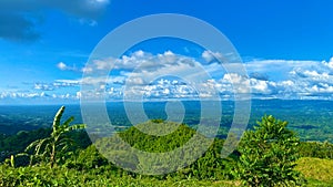 Wonderful springtime landscape in mountains. grassy field rolling hills. Green mountains and beautiful sky clouds under blue sky.