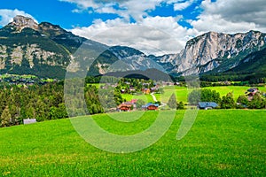 Wonderful summer alpine village landscape with green fields and mountains