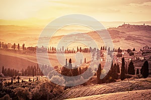Wonderful Tuscany landscape with cypress trees, farms and small medieval towns, Italy. Vintage sunset