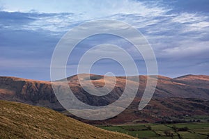 Wonderful vibrant sunset landscape image of view from Latrigg Fell towards Great Dodd and Stybarrow Dodd in Lake District photo