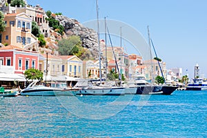 Wonderful view on colorful houses on rocks and sailing boats near the deep blue Mediterranian sea on Greek island photo