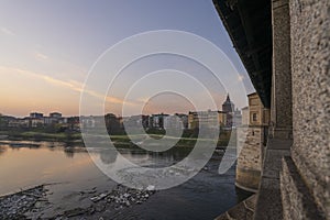 Wonderful view of covered bridge and Pavia Cathedral in background at sunset in Pavia