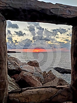 Wonderful view of the sea from a rocky beach at sunset