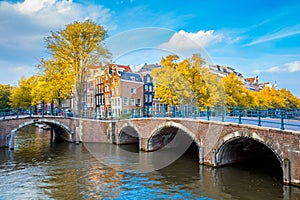 Wonderful view of the soul of Amsterdam. Beautiful autumn, golden falling leaves, old sloping houses, bridges, canals. Autumn day