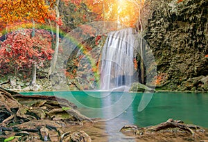 Wonderful Waterfall with rainbows and red leaf in Deep forest