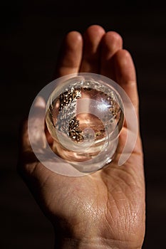 A wonderful wonderful world in the palm of your hand. A piece of nature under glass. The concept of a child`s play with glass