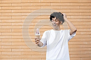 A wonderfully American man holding a white ice cream cone on an outstretched arm with hand in hair