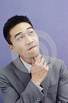 Wondering businessman touching his chin