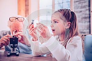 Wondering girl viewing at unknowing chemical equipment