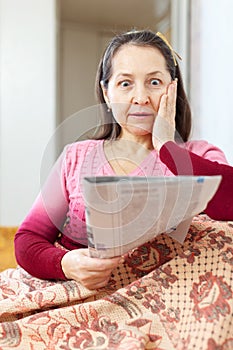 Wonderingly woman having grief after readed newspaper