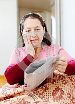 Wonderingly woman with newspaper