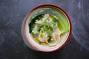 wonton soup or pangsit or dumplings soup and vegetable. wonton is traditional Chinese food of minced meat wrapped in flour sheets