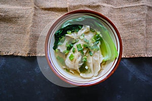 wonton soup or pangsit or dumplings soup and vegetable. wonton is traditional Chinese food of minced meat wrapped in flour sheets