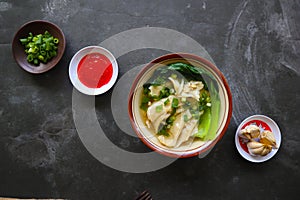 wonton soup or pangsit or dumplings soup and vegetable. wonton is traditional Chinese food of minced meat wrapped in flour sheets