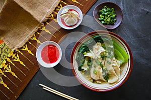 wonton soup or pangsit or dumplings soup and vegetable. wonton is traditional Chinese food of minced meat wrapped in flour sheets