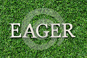 Wood letter in word eager on green grass background photo