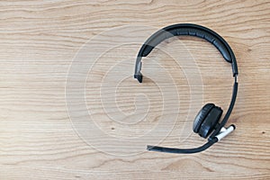 Wood background, headset and contact in call center for help desk, customer service or telemarketing. Tech support