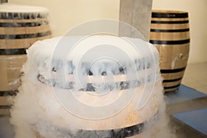 Wood barrel with red grapes and dry ice smoke in cellar  during harvest in saint emilion France