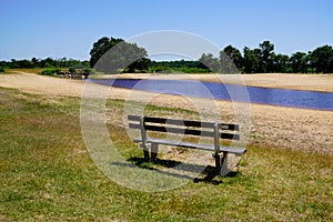 Wood bench empty in Ares lake sand wild beach calm water in gironde france