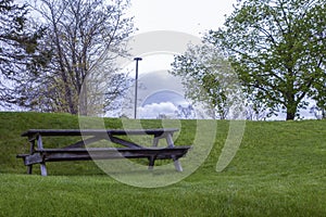 Wood bench on green grass with tall city street light day light