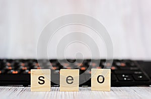 Wood block cube shape put the front computer keyboard with word SEO and empty copy space for your text. Search engine