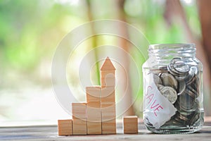 Wood block stacking as step stair and coins in jar glass, business growth to success.