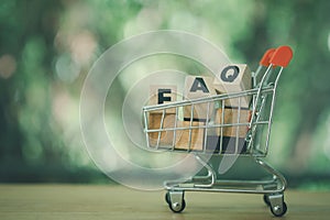 Wood block text FAQ placed in shopping cart