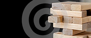 Wood block unstable staking. Wooden blocks tower with copy space on black background