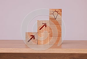 Wood, blocks and idea with light bulb icon for creativity, innovation and development with wooden cubes against studio