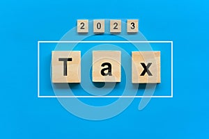 Wood blocks with tax word. Pay tax in 2023 years. The new year 2023 tax concept. Income tax return