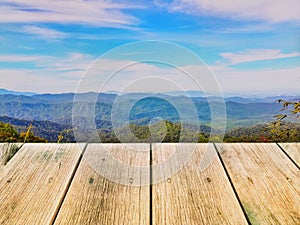 Wood board on mountain range in sunny day against beautiful blue sky, used for montage or display products among beautiful landsca