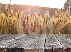 Wood board table in front of field of wheat on sunset light. Ready for product display montages