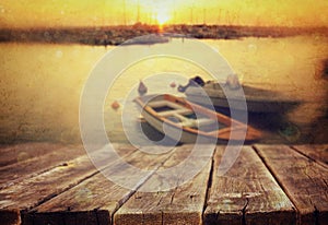 Wood boards in front of sea landscape and fishing boats.