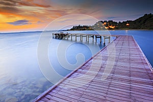 Wood bridge piers with nobody and smoothy sea water against beau