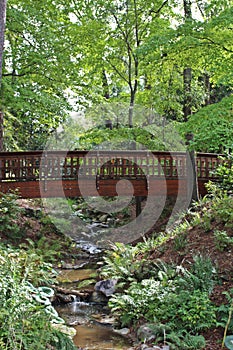 A wood bridge spanning a small stream in the woods on Durham, North Carolina