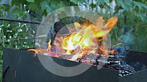 Wood burning in fire flame. Preparing BBQ or grill. Firewood burning in grill. Coals burning in fire flame on yard