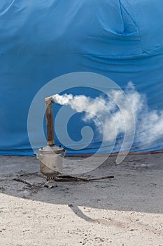 A wood-burning samovar with a chimney smokes.