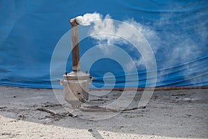 A wood-burning samovar with a chimney smokes.