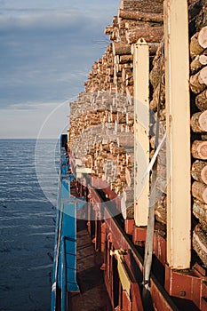 Wood carried by ship on deck.Ship sailing at sea.