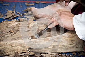 Wood carver man is using a wood chisel to extract. photo