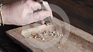 Wood carver processes a oak wood board with a chisel. woodworking process with hand tools in a carpentry workshop. wood carving