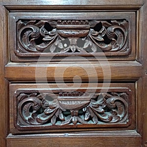 This is a wood carving on the surface of a drawer in a cupboard