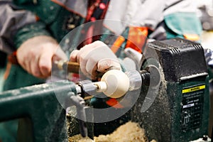 Wood carving on turning lathe machine with chisel