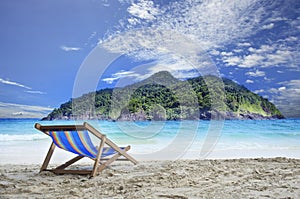 Wood chairs deck on white sand beach with clear blue sea water a